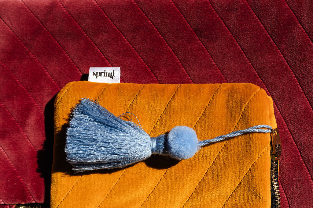 yellow clutch with blue tassel